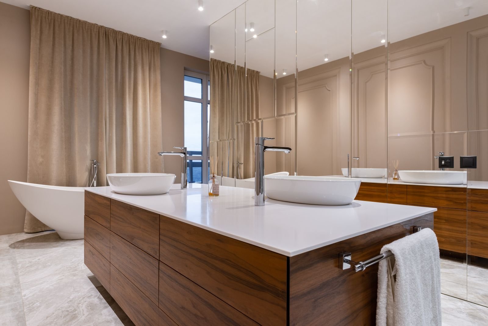 Minimal bathroom with white sink, bathtub and mirrored cabinet