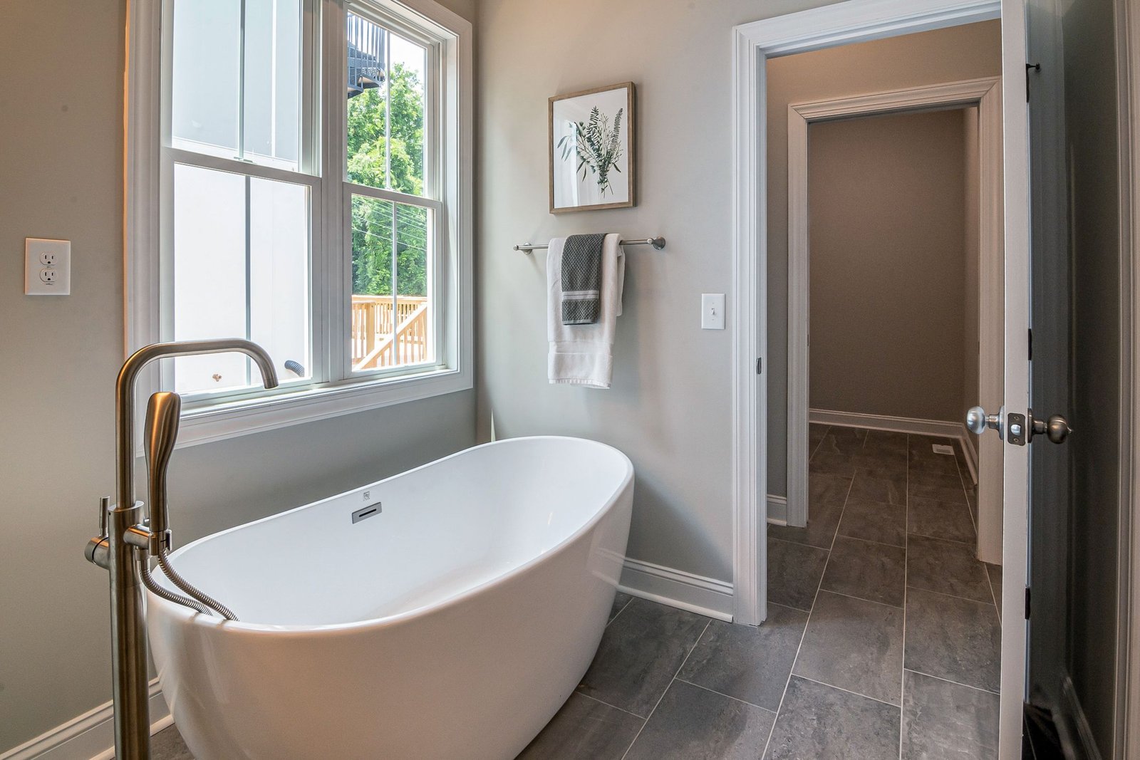 Bright bathroom with a freestanding soaking tub and bronze faucet